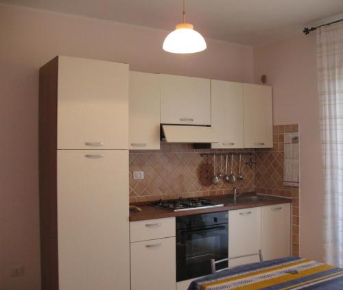 a kitchen with white cabinets and a refrigerator at LE DOMUS DE CHIA_Tipo A in Chia