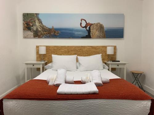 a bedroom with a large bed with white pillows at Pensión Amara in Donostia-San Sebastián