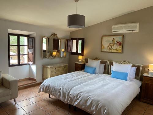 a bedroom with a large white bed with blue pillows at Finca Sa Canova Agroturismo in Campos