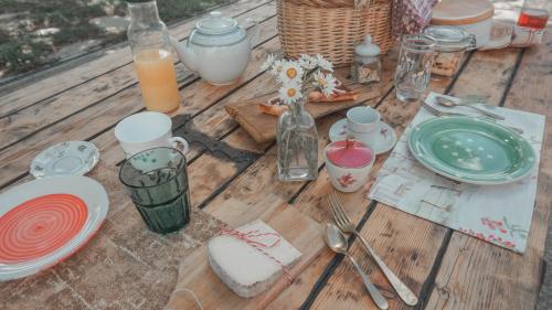 a wooden table with plates and utensils on it at B&B La Buonora in Sinio
