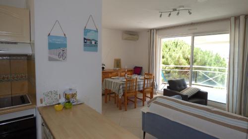 une cuisine et un salon avec une table et une salle à manger dans l'établissement Appartement T3 climatisé, Les Bastides de la Plage, Narbonne Plage, à Narbonne-Plage