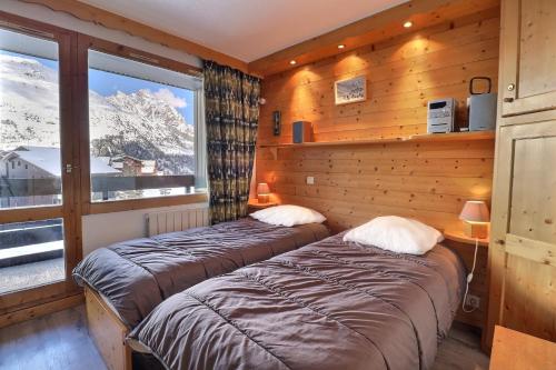 - 2 lits dans une chambre avec vue sur la montagne dans l'établissement Résidence Creux de l'ours D et C, à Méribel