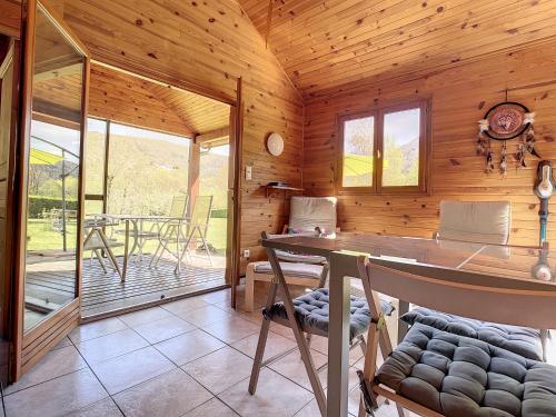 a wooden cabin with a table and a dining room at Chalet grand jardin, au calme, proche commerces in La Canourgue