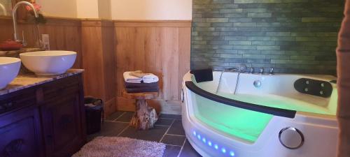 a bathroom with a tub and two sinks at De Blauwe Maaten in Neerglabbeek