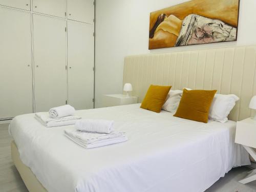 a bedroom with a white bed with towels on it at Dom Quixote apartamentos turísticos in Praia de Mira