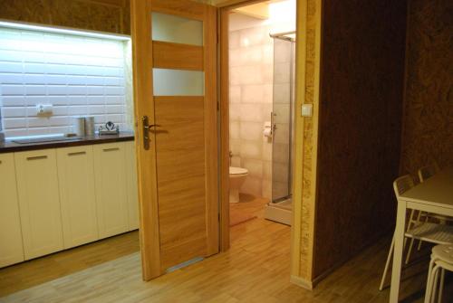a bathroom with a door leading to a toilet at Cichosza Miłomłyn in Miłomłyn