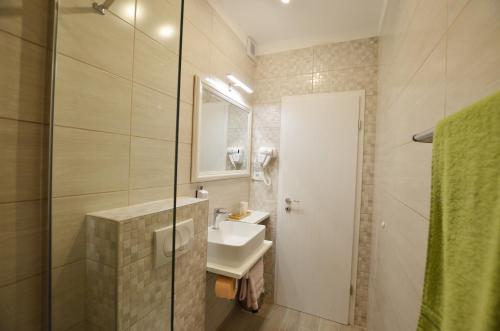 W łazience znajduje się umywalka, lustro i prysznic. w obiekcie Katy Apartment w Rovinj