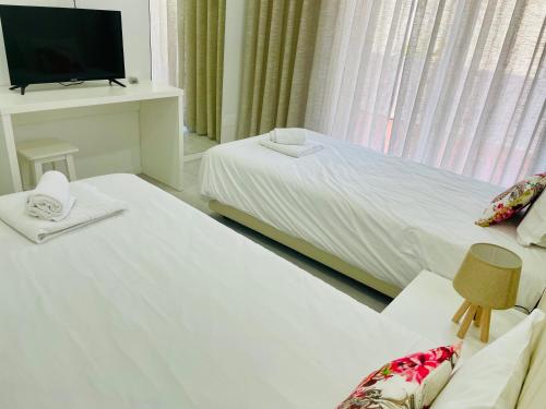 a hotel room with a bed and a television at Dom Quixote apartamentos turísticos in Praia de Mira
