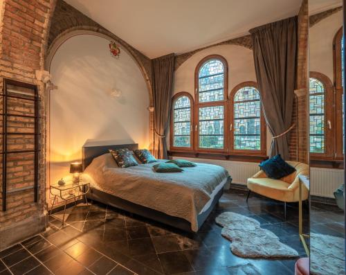 um quarto com uma cama num quarto com janelas em LOFT d'O em Ypres