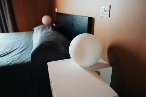 a room with a bed and a white lamp on a table at Ristolocanda Grani Di Pepe in Flaibano