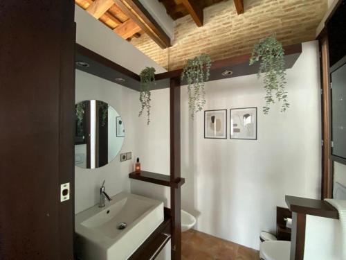 uma casa de banho com um lavatório e um espelho em Hostfy Centro, Puerta Osario em Sevilha