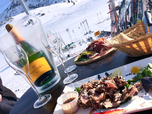 - une table avec une assiette de nourriture et une bouteille de vin dans l'établissement 5* Flat - 6 people - Arc 1950 - Sun - View - SPA, à Bourg-Saint-Maurice