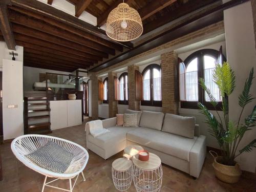 - un salon avec un canapé, une table et des chaises dans l'établissement Hostfy Centro, Puerta Osario, à Séville
