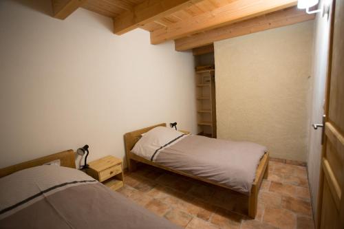 a bedroom with two beds and a closet at Gîtes du Pont de Calmel in Rieussec