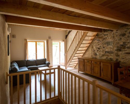a living room with a couch on a balcony at Gîtes du Pont de Calmel in Rieussec