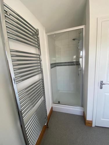 La salle de bains est pourvue d'une douche et d'une porte en verre. dans l'établissement Lovely 1 bedroom apartment in Norwich, à Norwich