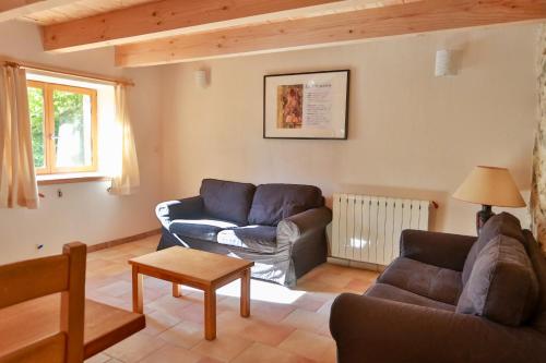 a living room with two couches and a table at Gîtes du Pont de Calmel in Rieussec