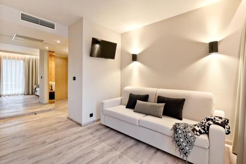 a living room with a white couch and a television at Harda House Friends & Spa in Zakopane