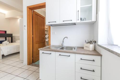 a kitchen with white cabinets and a sink at La Gemma del Salento Rooms&Apartments in Racale