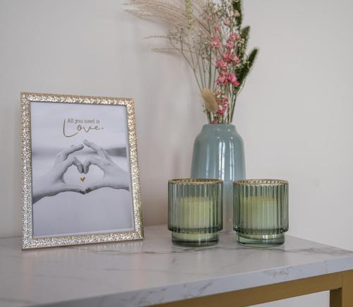 a table with two candles and a picture and a vase at LOFT d'O in Ypres
