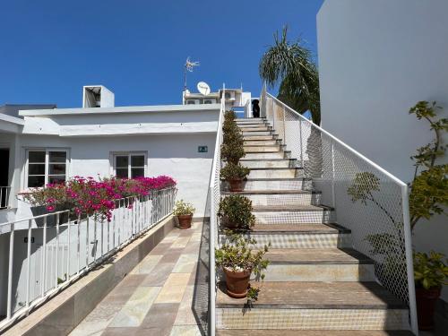 a staircase leading up to a house with potted plants at Chipibeach B&B, Hostal Boutique in Chipiona