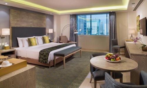 マスカットにあるCentara Muscat Hotel Omanのベッドとリビングルームがあるホテルの部屋