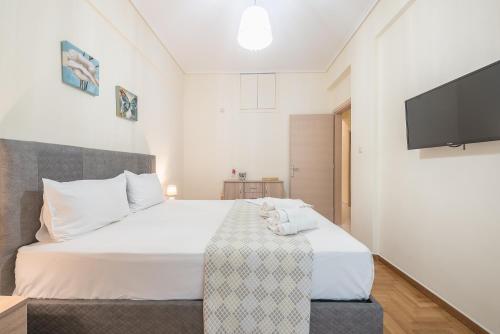 sypialnia z łóżkiem i telewizorem z płaskim ekranem w obiekcie Elegant Home in Quiet Street by Cloudkeys w Atenach