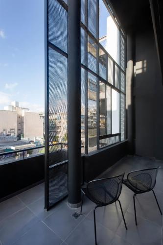 two chairs in a room with a large window at Thisean Modern Suites By Athens Stay in Athens