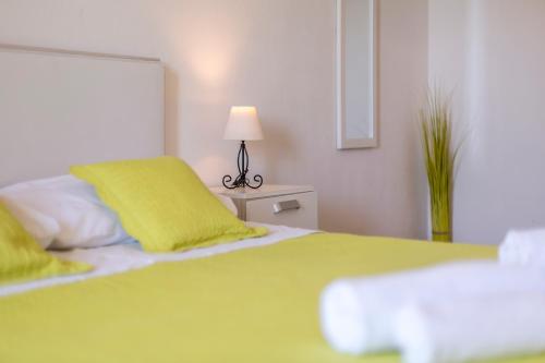 a bedroom with a green bed and a lamp at Hvar De Luxe Apartments in Hvar