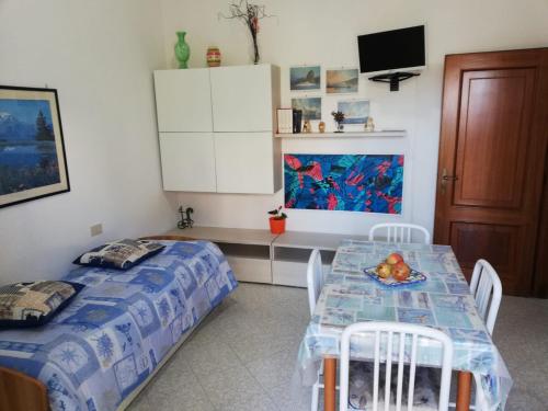 a bedroom with a bed and a table and a tv at Rose Apartment in Gaeta