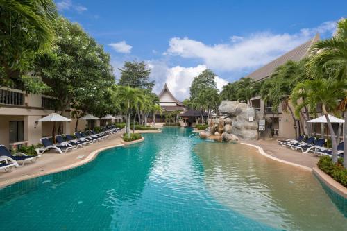 einen Pool in einem Resort mit Stühlen und einer Wasserrutsche in der Unterkunft Centara Kata Resort Phuket in Kata Beach