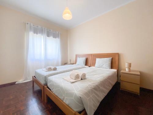 een slaapkamer met een groot bed en handdoeken bij Casa Rita - Close to the city centre within walking distance to the beaches in Lagos