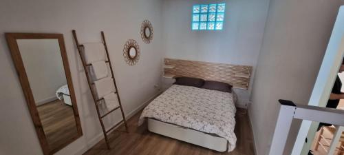 Dormitorio pequeño con cama y espejo en Atico Sagrada Familia, en Barcelona