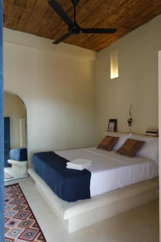 a bedroom with a large bed with a ceiling fan at Casa De Amigos Hotel Boutique in Honda