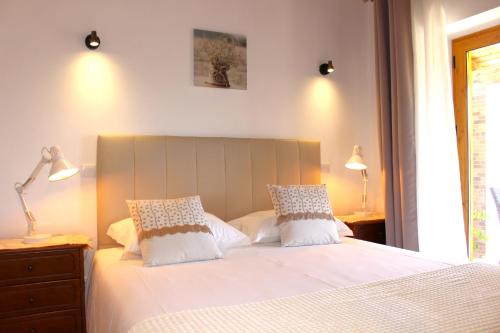 a bedroom with a large white bed with two pillows at Quinta das Alfambras in Aljezur