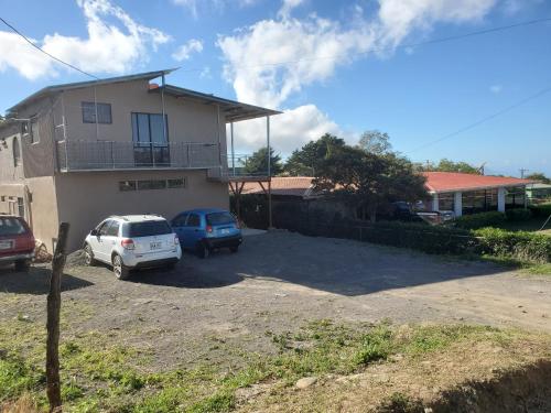 ein Haus mit zwei Autos, die in einer Einfahrt geparkt sind in der Unterkunft Ocean view in Monteverde Costa Rica