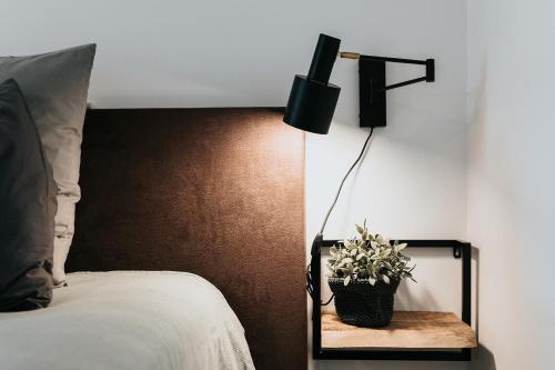 a bedroom with a bed with a lamp and a plant at Vida Verde in Valkenburg