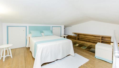 Dormitorio blanco con cama y mesa en Ferienwohnung Chiara, en Seneghe