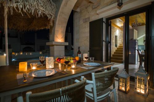 a restaurant with a table with plates and wine glasses at Villa Constancia in Stalos