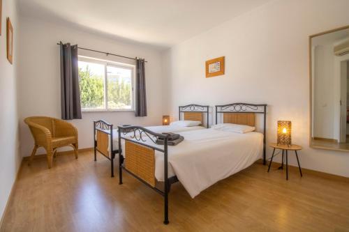 a bedroom with a bed and a window at Apartamento Jacadi in Ferragudo