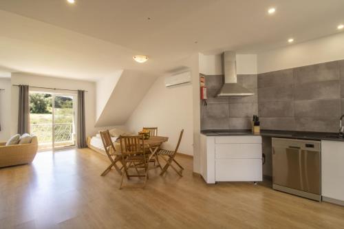a kitchen and dining room with a table and chairs at Apartamento Jacadi in Ferragudo