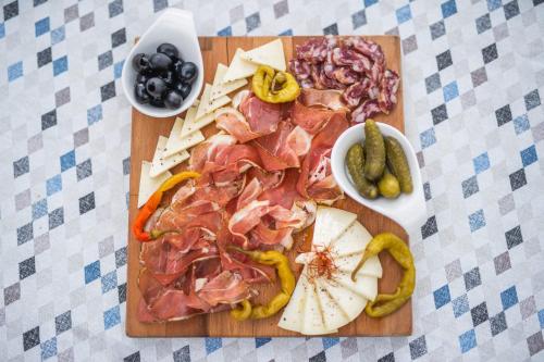a cutting board with meats and vegetables on a table at Ponte Porton Dining & lodging in Grožnjan