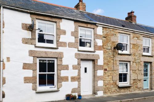 an old stone house with white windows at Finest Retreats - Coral Cottage in Porthleven