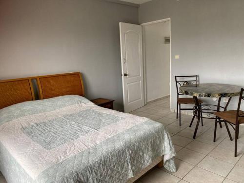 a bedroom with a bed and a table and chairs at Beautiful studio Jordan Village - 5min from AUC School of Medicine in Cul de Sac