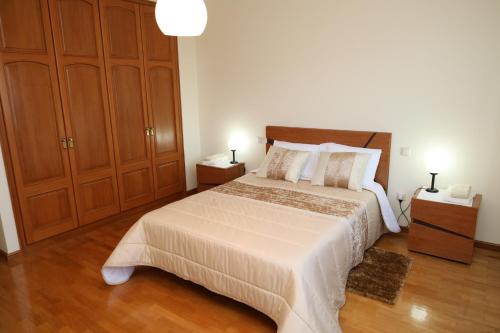 sypialnia z dużym łóżkiem i drewnianymi szafkami w obiekcie Porto Cruz w mieście Vila Nova de Gaia