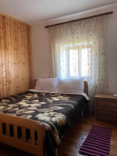 a bedroom with a large bed and a window at Guest House Sabriu in Rabdisht