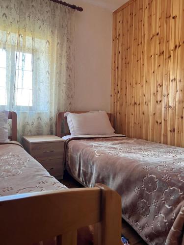 a bedroom with two beds and a window at Guest House Sabriu in Rabdisht