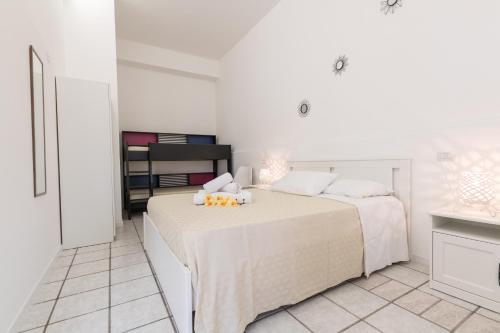 a white bedroom with two beds and a counter at La Gemma del Salento Rooms&Apartments in Racale