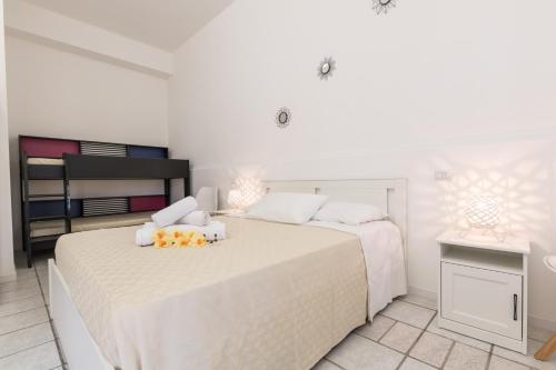 a white bedroom with two beds with white sheets at La Gemma del Salento Rooms&Apartments in Racale