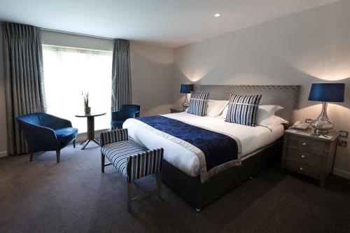 a hotel room with a bed and a desk and chair at Sandford Springs Hotel and Golf Club in Kingsclere